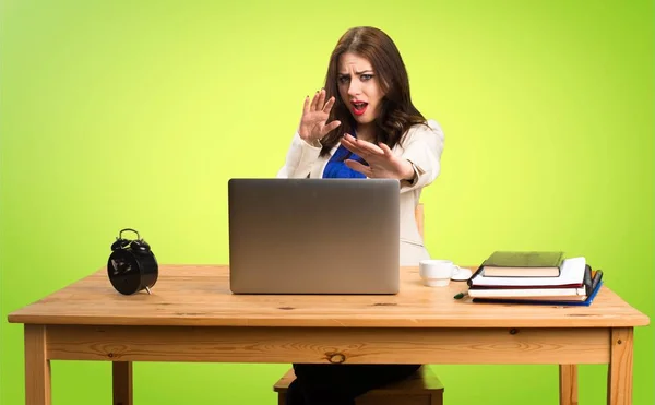 Onu laptop ile renkli ba üzerinde çalışan korkmuş iş kadın — Stok fotoğraf