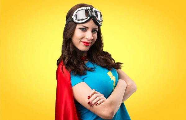 Bastante chica superhéroe con sus brazos cruzados en backgrou colorido — Foto de Stock