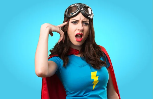 Menina super-herói bonito fazendo gesto louco em backgroun colorido — Fotografia de Stock