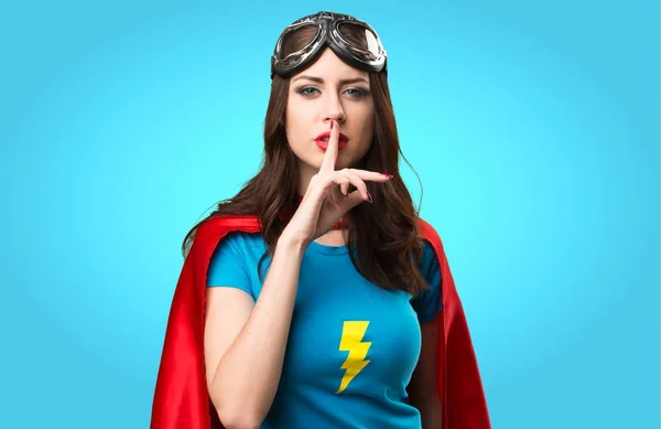 Hezká superhrdina dívka dělat mlčení gesto na barevné backgro — Stock fotografie