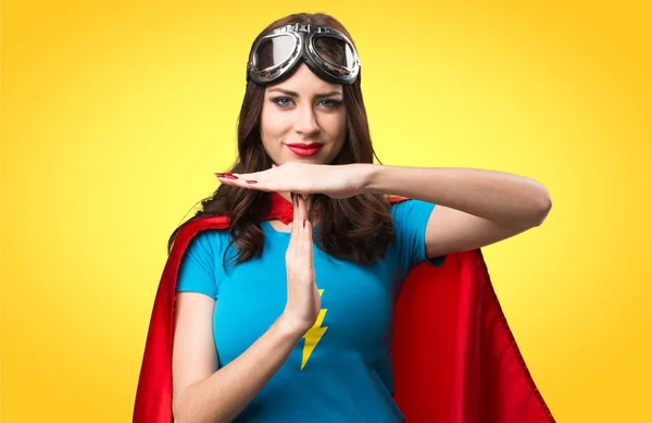 Hezká superhrdina dívka dělat časový limit gesto na barevné pozadí — Stock fotografie