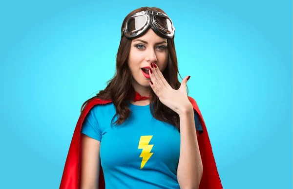 Hezká superhrdina dívka dělat překvapení gesto na barevné pozadí — Stock fotografie