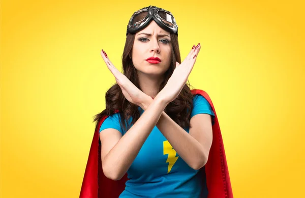 Dívka hezká superhrdina dělat žádné gesto na barevné pozadí — Stock fotografie