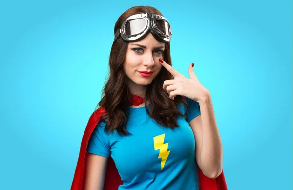 Bastante chica superhéroe mostrando algo en fondo colorido —  Fotos de Stock