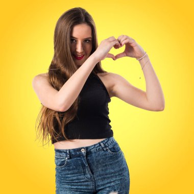 Genç kız elleri ile bir kalp yapma