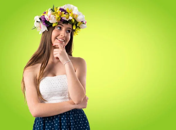 Girl with crown of flowers thinking — Stock Photo, Image