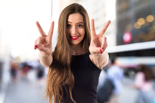 Chica joven haciendo gesto de victoria —  Fotos de Stock