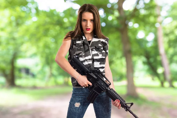 Jovencita sosteniendo un rifle — Foto de Stock