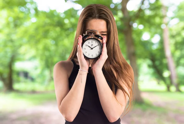 Chica joven sosteniendo reloj vintage —  Fotos de Stock