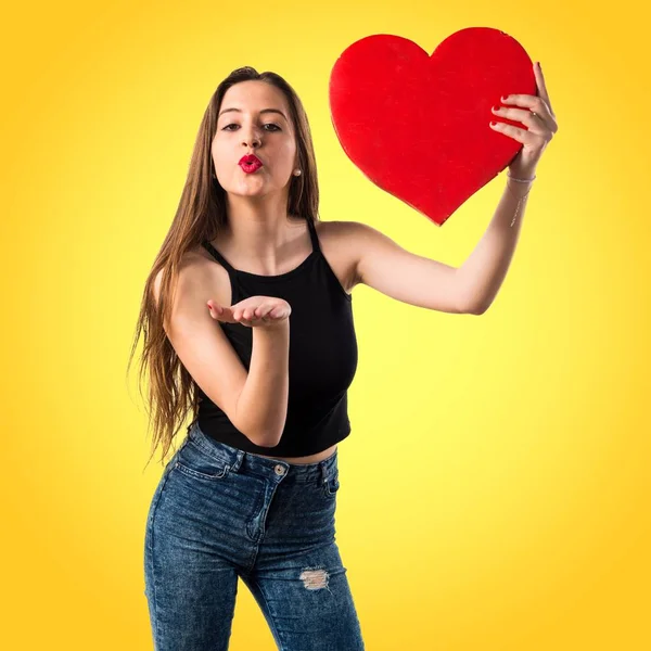 Chica joven sosteniendo un símbolo del corazón —  Fotos de Stock