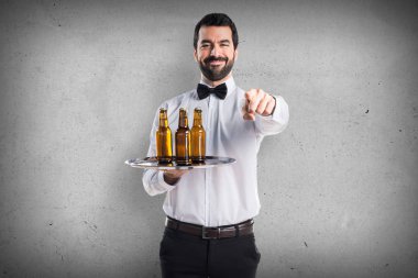 Garson bira şişeleri önüne işaret tepsi ile