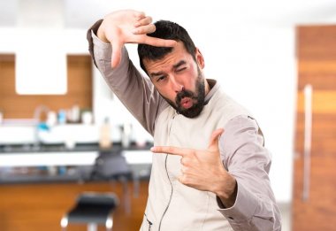 Evin içinde parmaklarıyla yelek odaklanan yakışıklı adam