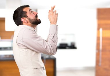 Evin içinde geçiş parmaklarıyla yelek ile yakışıklı adam