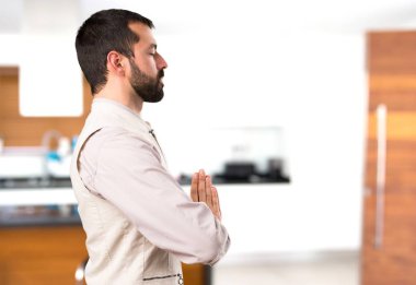 Evin içinde zen pozisyonda yelek ile yakışıklı adam