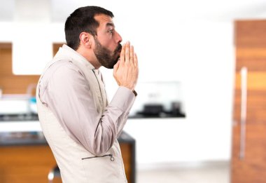 Evin içinde yalvaran yelek ile yakışıklı adam