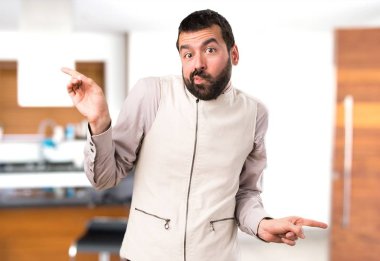 Evin içinde şüpheleri laterallerin işaret eden yelek ile yakışıklı adam