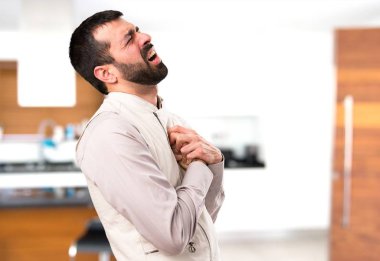 Evin içinde kalp acıyla yelek ile yakışıklı adam