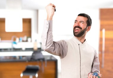 Evin içinde poker fişleri tutan yelek ile yakışıklı adam