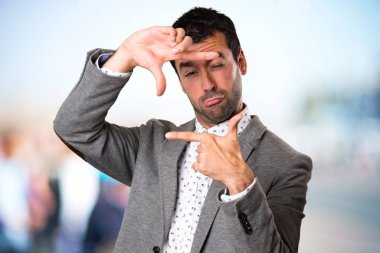 Yakışıklı adam onun parmaklarıyla odaklanmamış arka plan üzerinde duruluyor