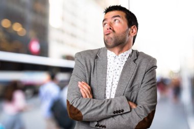 Yakışıklı adam odaklanmamış arka plan üzerinde önemsiz jest yapma