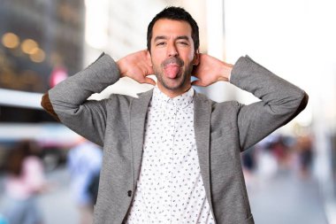 Yakışıklı adam odaklanmamış arka plan üzerinde bir şaka yapmak