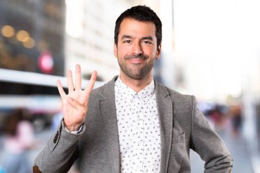 Yakışıklı adam dört odaklanmamış arka plan üzerinde sayma