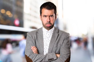 Odaklanmamış arka plan üzerinde üzgün yakışıklı adam