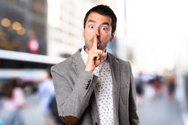 Yakışıklı adam yapma sessizlik jest odaklanmamış arka plan üzerinde