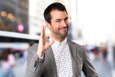 Yakışıklı adam Tamam odaklanmamış arka plan üzerinde kayıt yapma