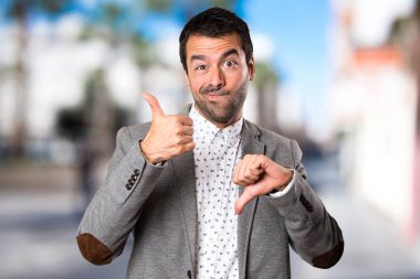 Yakışıklı adam iyi-kötü işaret odaklanmamış arka plan yapma