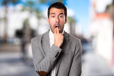 Yakışıklı adam odaklanmamış arka plan üzerine kusma jest yapma