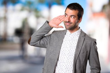 Yakışıklı adam odaklanmamış arka planda bir şey dinleme