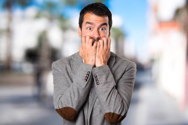 Odaklanmamış arka plan üzerinde korkmuş yakışıklı adam