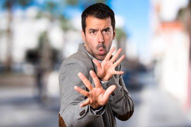 Yakışıklı adam odaklanmamış arka plan üzerinde hiçbir hareketi yapma