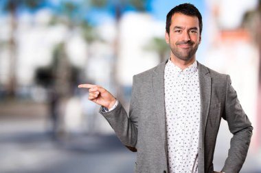 Yakışıklı adam lateral odaklanmamış zemin üzerine işaret