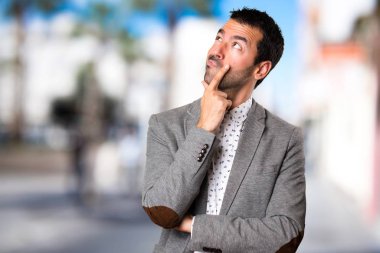 Yakışıklı adam odaklanmamış arka plan üzerinde düşünme