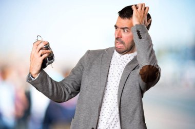 Vintage saat odaklanmamış arka planda tutan sinirli yakışıklı adam