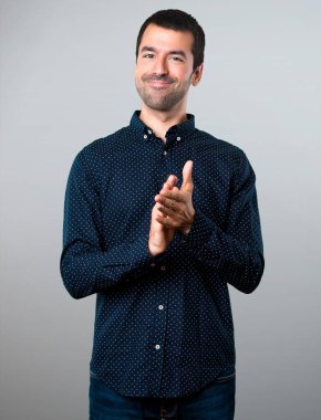 Yakışıklı adam gri arka plan üzerinde alkış
