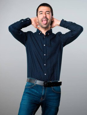 Yakışıklı adam gri arka plan üzerinde bir şaka yapmak