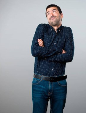 Yakışıklı adam gri arka plan üzerinde önemsiz jest yapma