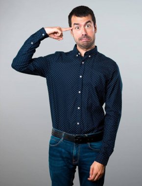 Yakışıklı adam gri arka plan üzerinde deli jest yapma