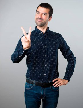 Yakışıklı adam iki gri arka plan üzerinde sayma