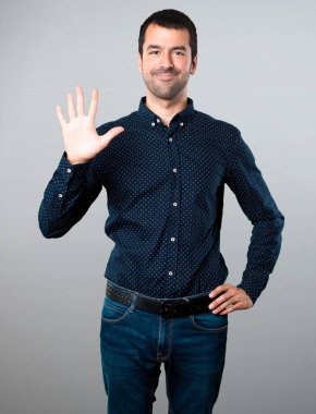 Yakışıklı adam beş gri arka plan üzerinde sayma