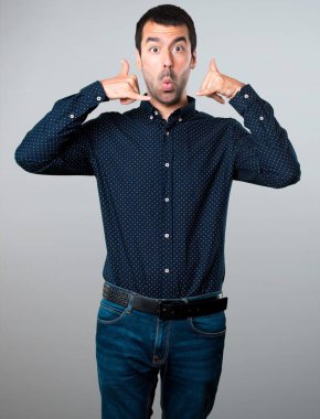 Yakışıklı adam yapım telefon jest gri arka plan üzerinde