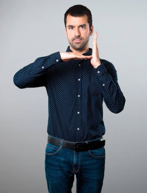 Yakışıklı adam yapma zaman aşımı jest gri arka plan üzerinde