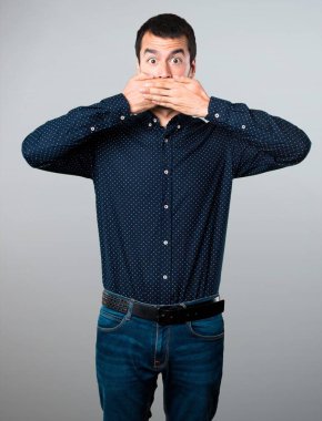 Yakışıklı adam ağzını gri arka plan üzerine kaplama