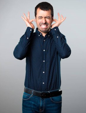 Yakışıklı adam gri arka plan üzerinde kulakları kapsayan