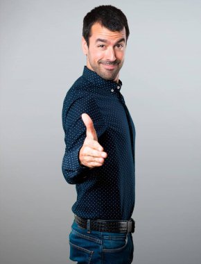 Yakışıklı adam gri arka plan üzerinde anlaşma