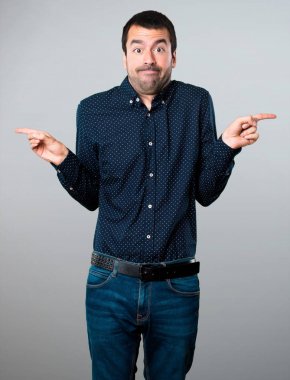 Yakışıklı adam gri arka plan üzerine şüpheleri laterallerin işaret