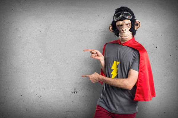 Superhero monkey man pointing to the lateral